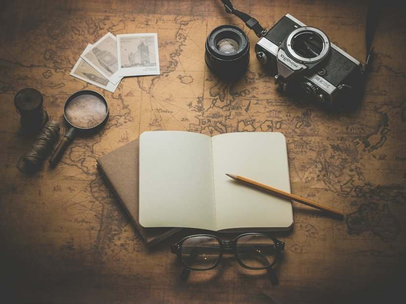 Libreta, cámara y gafas de sol preparados para un viaje